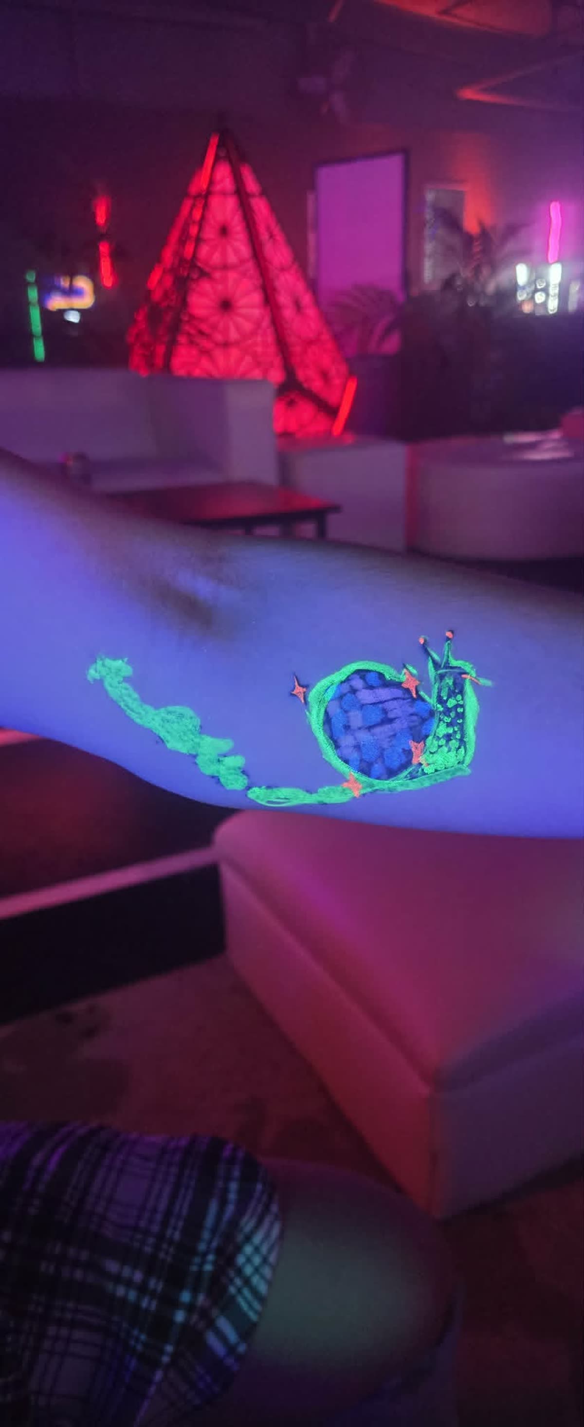 Glowing UV marker drawing on arm under blacklight