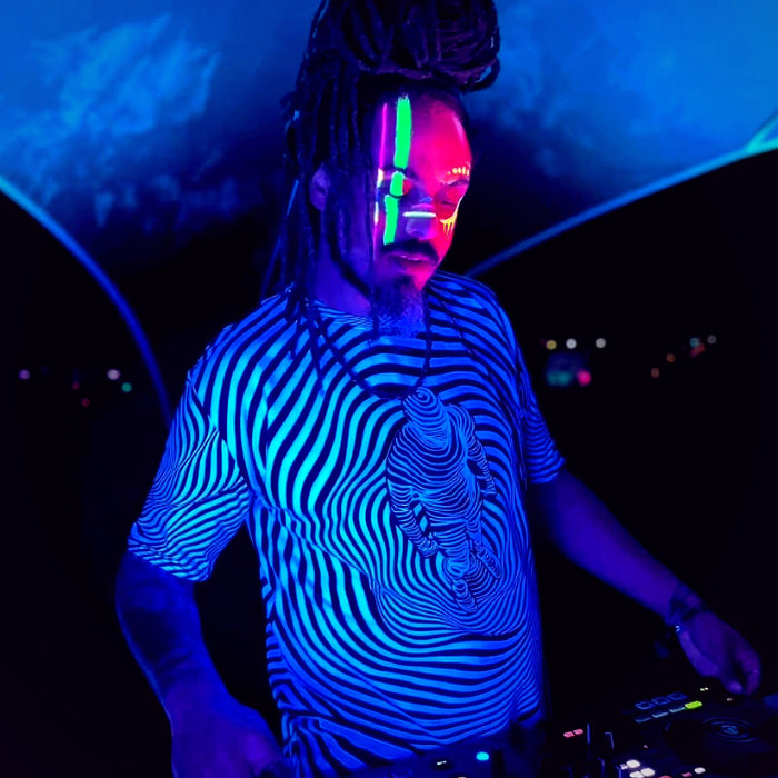DJ in a Mothership shirt and UV face paint glowing under black light